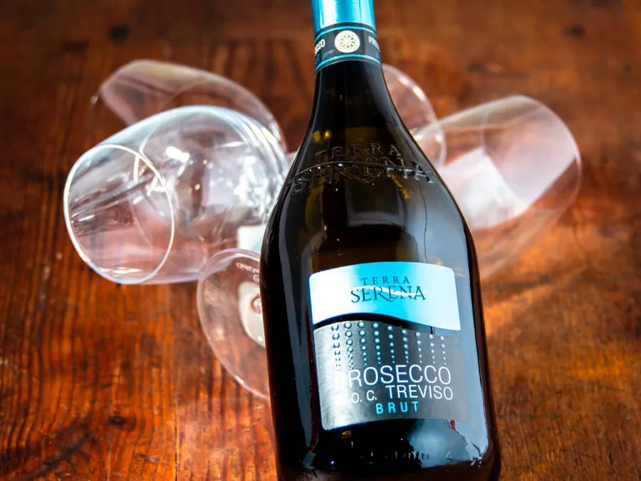 Bouteille de prosecco et verres sur une table en bois