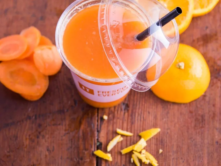 Jus de fruits frais pressé, servi sur une table en bois